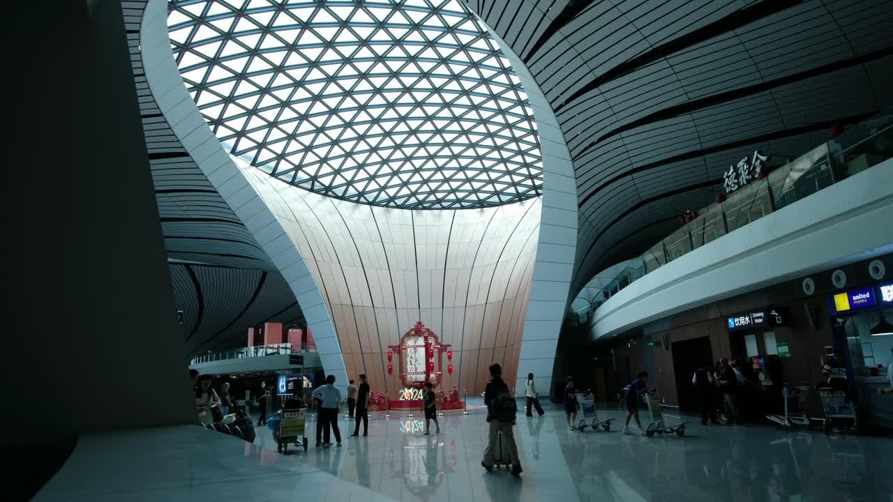 Daxing beijing airport central courtyard with futuristic ceiling and light play with busy travellers