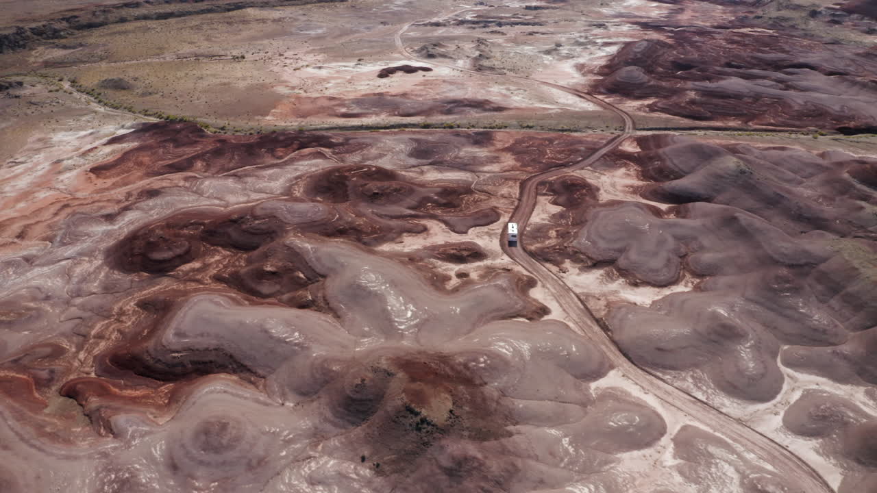 Un'ampia ripresa aerea di un camper che attraversa il deserto dello Utah con bizzarre formazioni rocciose.
