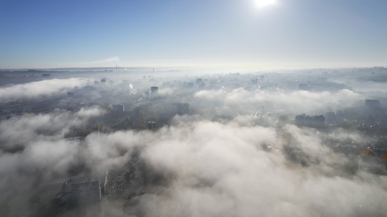 Aerial drone view of Chisinau at sunrise, Moldova. View of city centre covered with fog and low clouds. Dendrarium park, multiple buildings