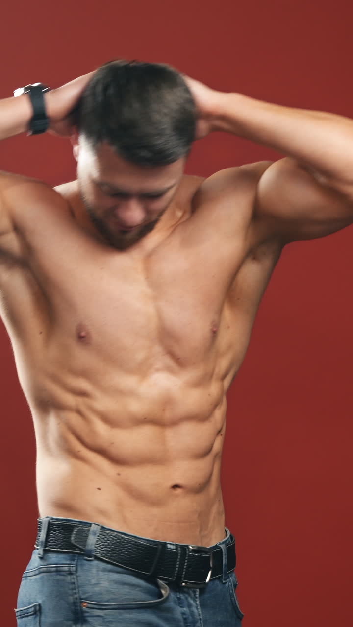 Strong Athletic Man Fitness Model Torso showing six pack abs. isolated on darkred background. half length video. Vertical video