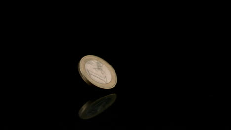 moneda de euro que gira sobre una superficie negra