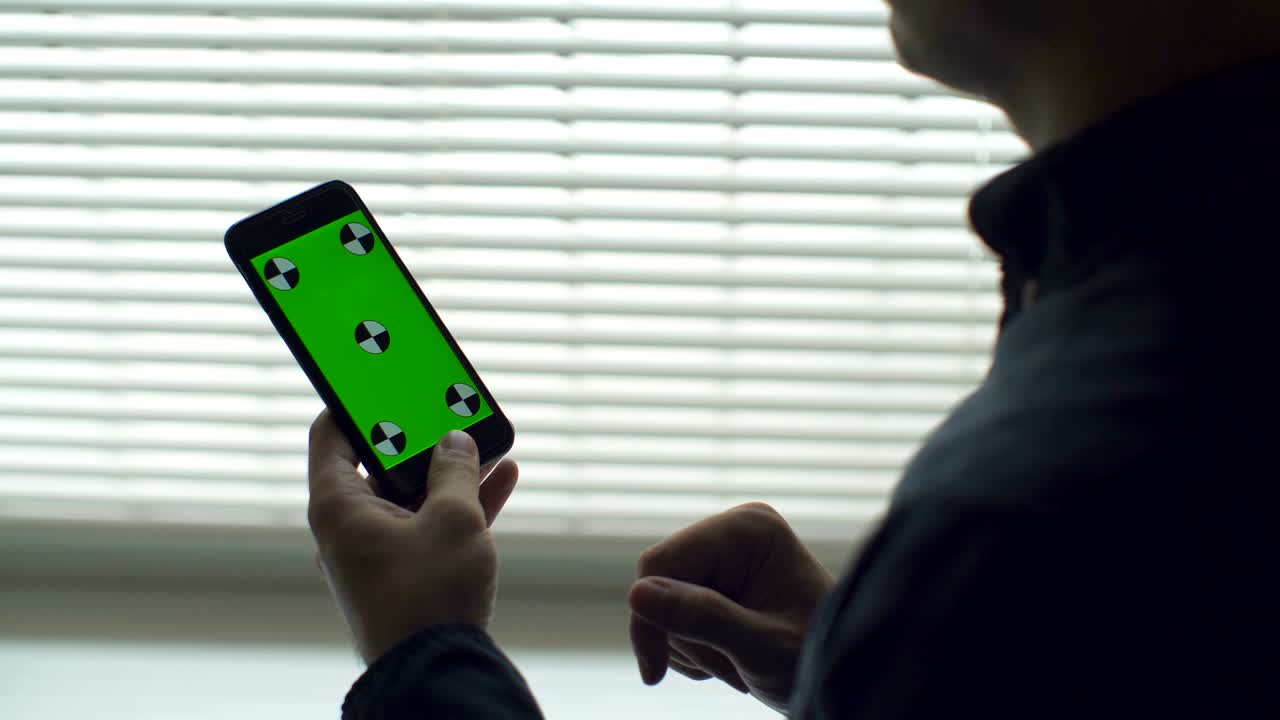Man Holding Smartphone Touch Screen With Green Screen Chroma Key For Custom Content