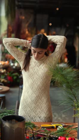 woman decorating christmas floral arrangements