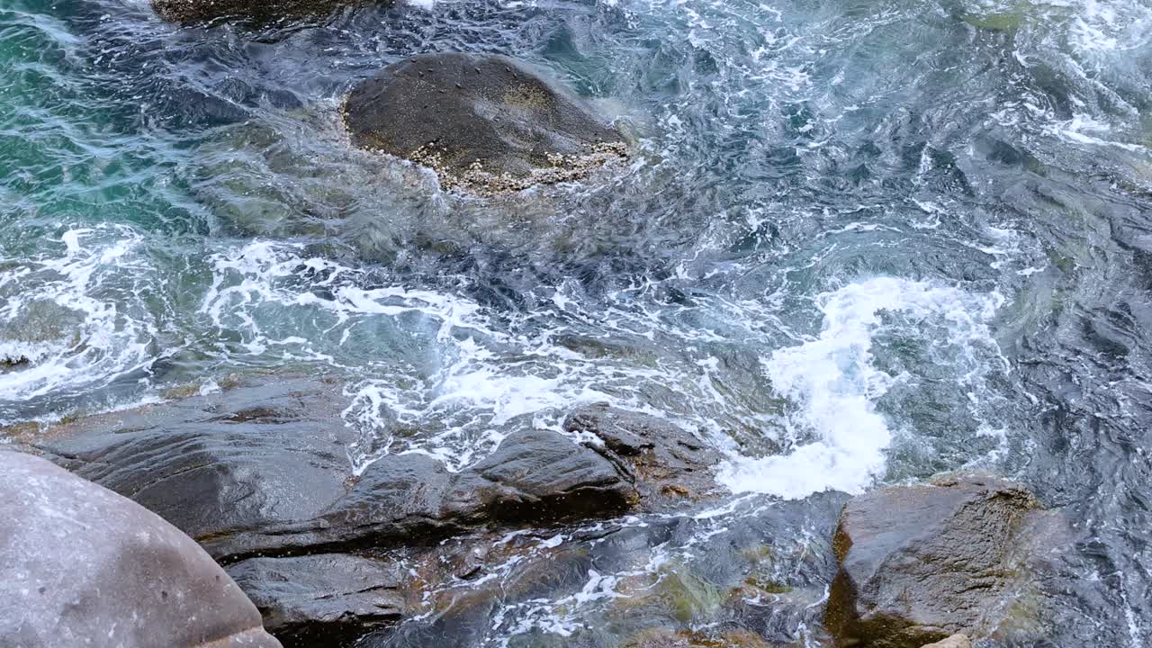 바위 해안에 부히는 역동적인 바다 파도