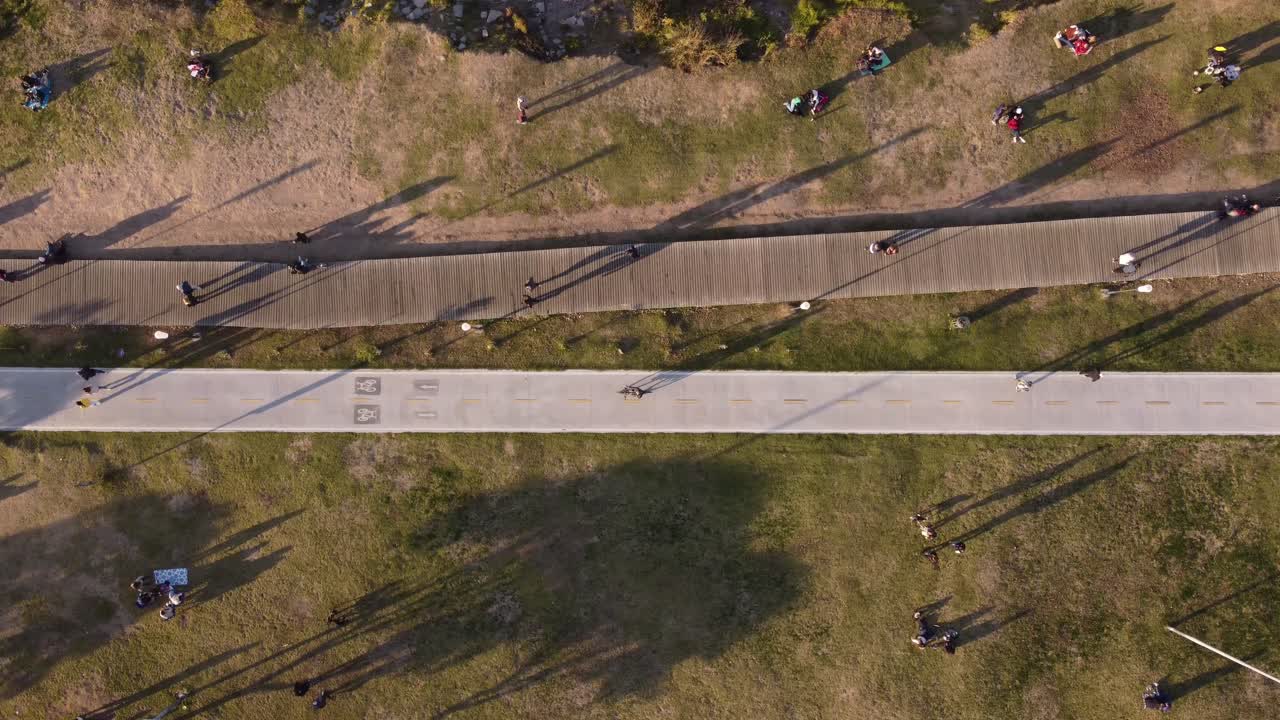 아르헨티나 부에노스아이레스 주에 있는 비센테 로페즈 자연 공원의 해안 도로를 따라 걷고 자전거를 타는 사람들