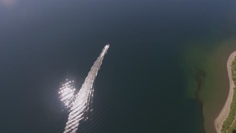 rotating aerial of a motorboat rounding a point of land