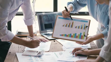 business professionals working together at office desk, hands close up pointing out financial data on a report, teamwork concept. financial and investment.