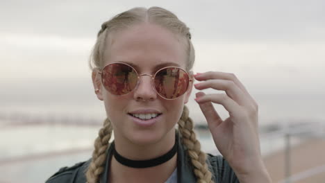 retrato de una mujer rubia atractiva y audaz se quita las gafas de sol sonriendo optimista