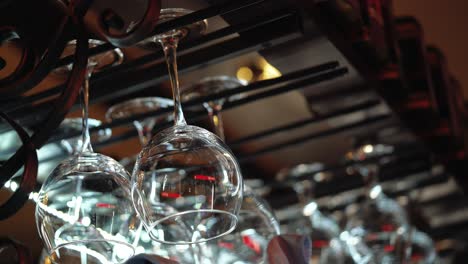 clean wine glasses prepared by bartender and hung on the bar at a restaurant or cafe. glasses prepared for a party at the bar.