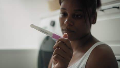 primer plano de una mujer afroamericana estresada esperando los resultados de la prueba de embarazo.