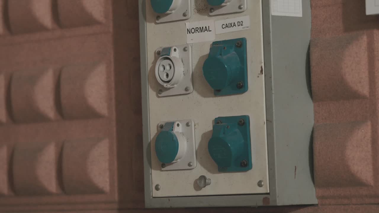 Close up of electrical distribution box with blue connectors on brick wall