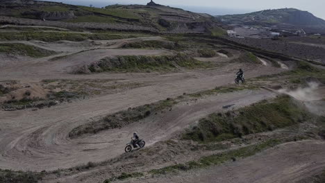 Toma-Aérea-Panorámica-A-La-Izquierda-Mientras-Los-Pilotos-En-La-Pista-De-Motocross-Dan-Un-Salto