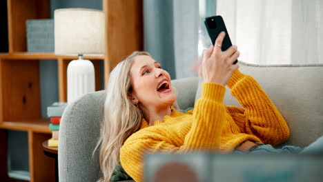 a woman relaxing on the couch while using her phone