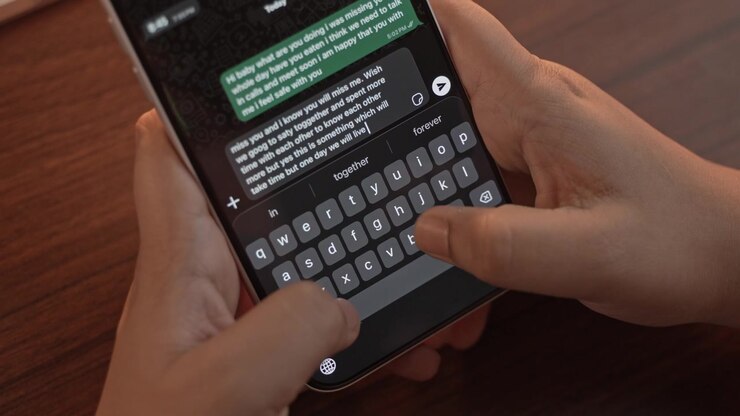 Woman's hand chatting and typing on a smartphone, macro closeup. Unrecognisable human typing a text message, tapping the touchscreen keyboard using the WhatsApp application, a social media.