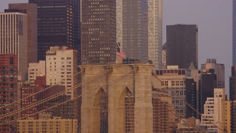 wide shot of waving american flag on brooklyn bridge during golden hour, nyc