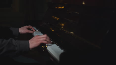 person playing piano in a dark room