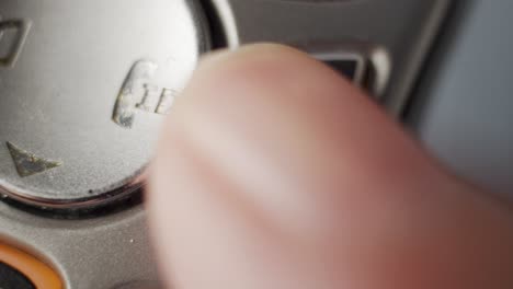 macro shot of a finger hanging up a cordless phone