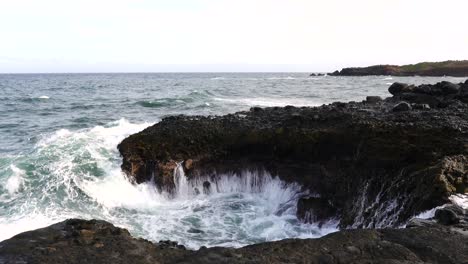 The-ocean-waves-breaking-on-the-rocks-along-the-seashore-casting-spray-into-the-air