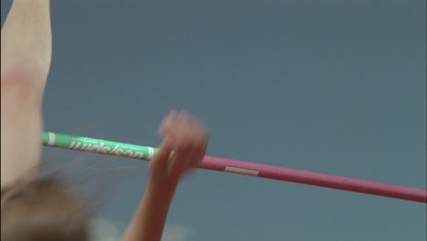 a young woman high jumps over a pole