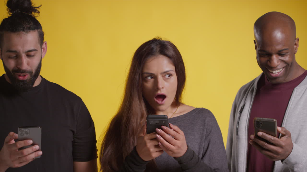 노란색 배경 2에 대해 돈을 이기는 것을 축하하는 휴대 전화로 친구 그룹의 스튜디오