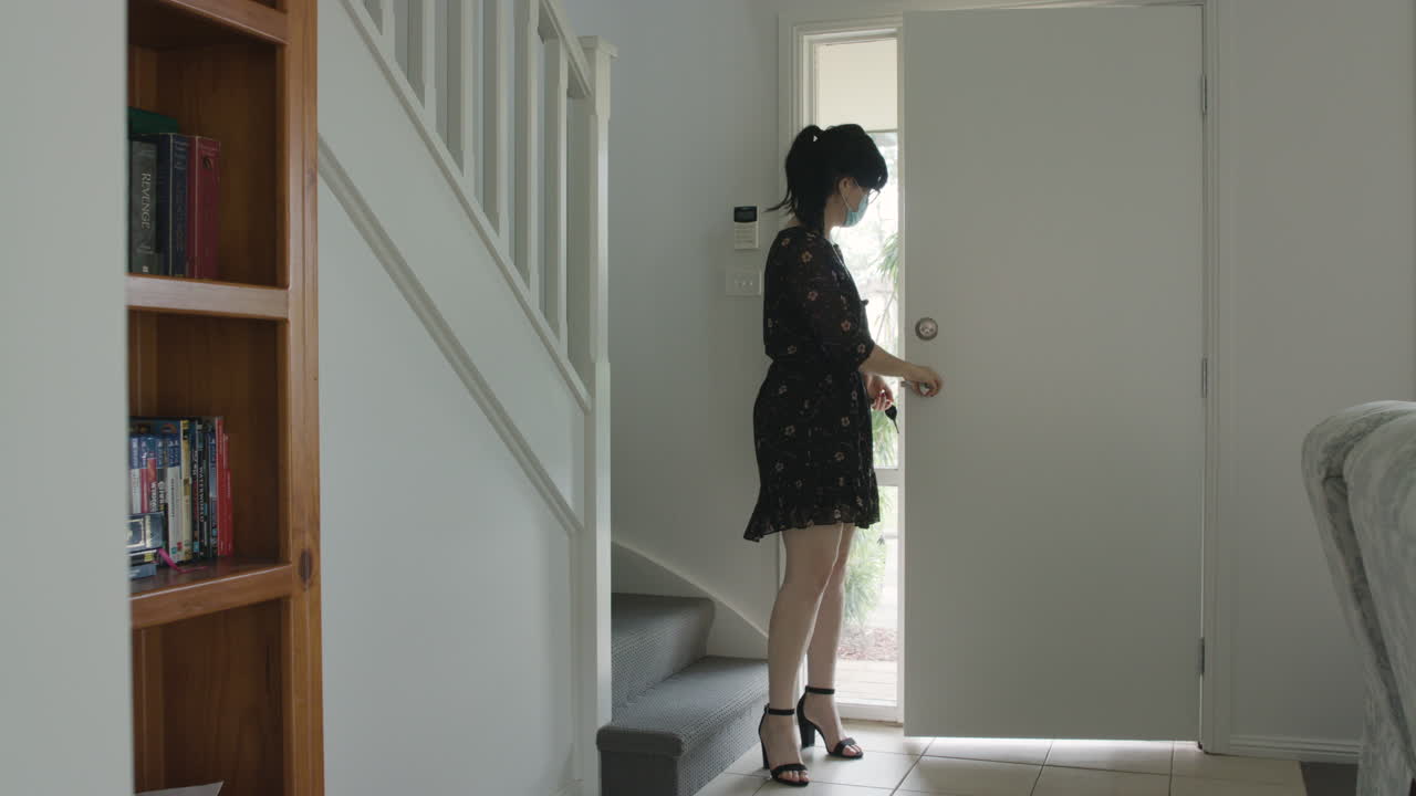 비즈니스 여성은 집에 도착하여 무엇이든 할 준비가 된 마스크를 벗습니다.