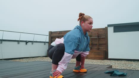 fit girl making workout cardio training exercises outdoors squats yoga stretching exercising on roof