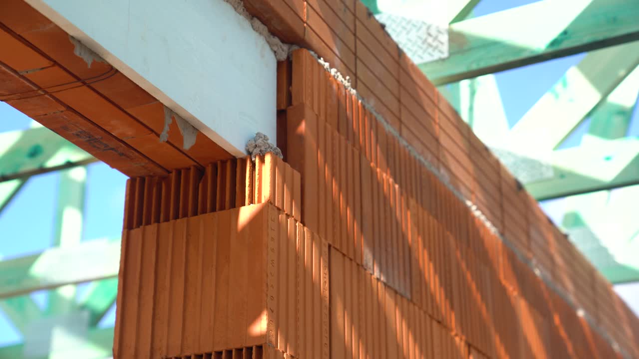 Brick wall corner with reinforced beam under impregnated timber roof structure