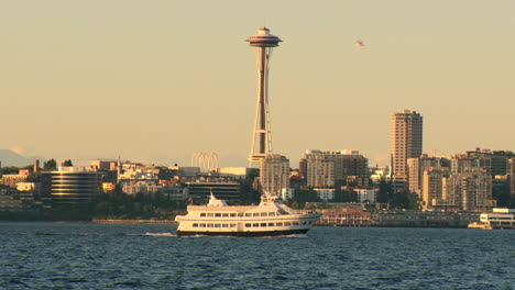 Puesta-De-Sol-En-Elliot-Bay-En-Seattle-Con-Cruce-En-Ferry-Frente-A-La-Aguja-Espacial