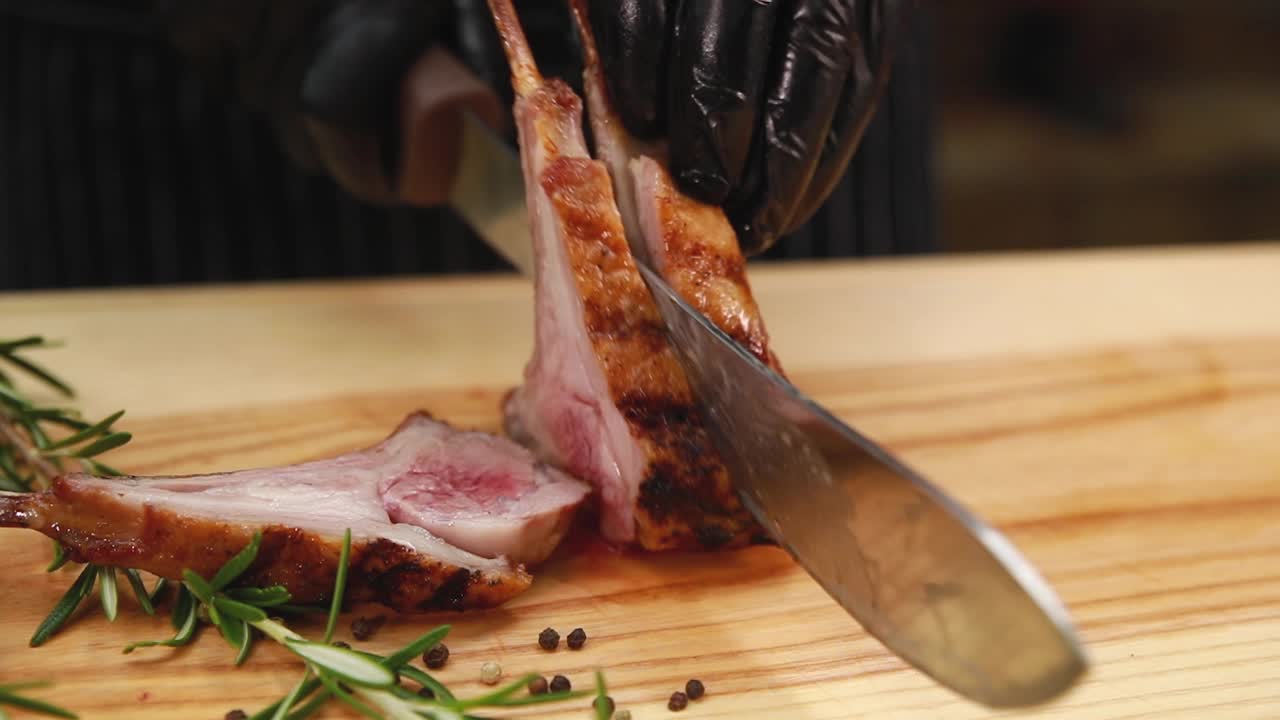 chef cortando chuletas de cordero a la parrilla
