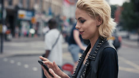 retrato en cámara lenta de una feliz y hermosa mujer punk caucásica usando un teléfono inteligente