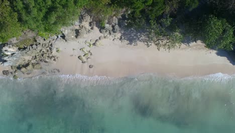 Beautiful-aerial-shot-with-drone-on-a-beautiful-beach-watching-the-white-sand-and-splash-waves,-on-a-sunny-morning