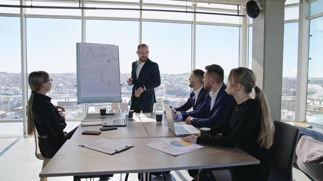 Successful business speaker performs a speech using a chart. Business communication among the coworkers in the office.