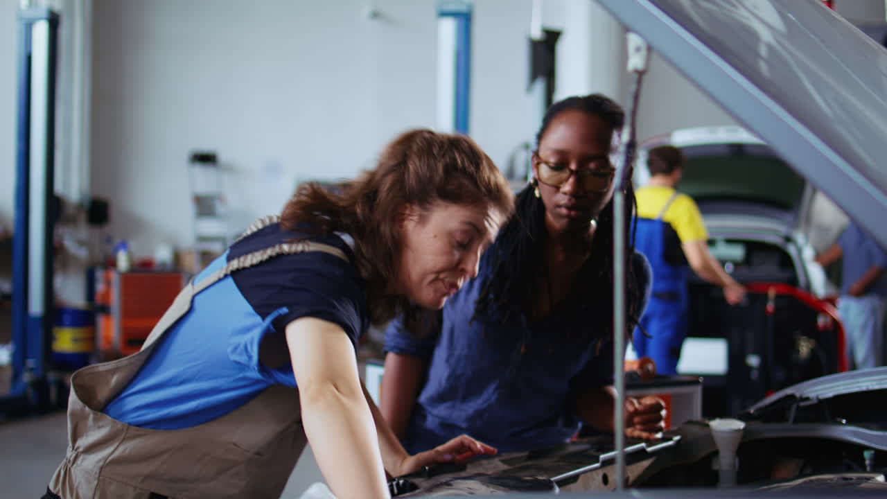 Repairman in garage cleans customers car