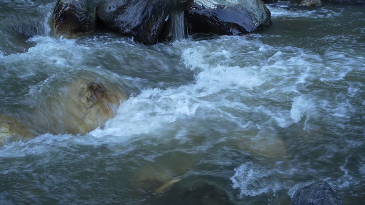 L'acqua scorre attraverso un fiume montano torrenziale