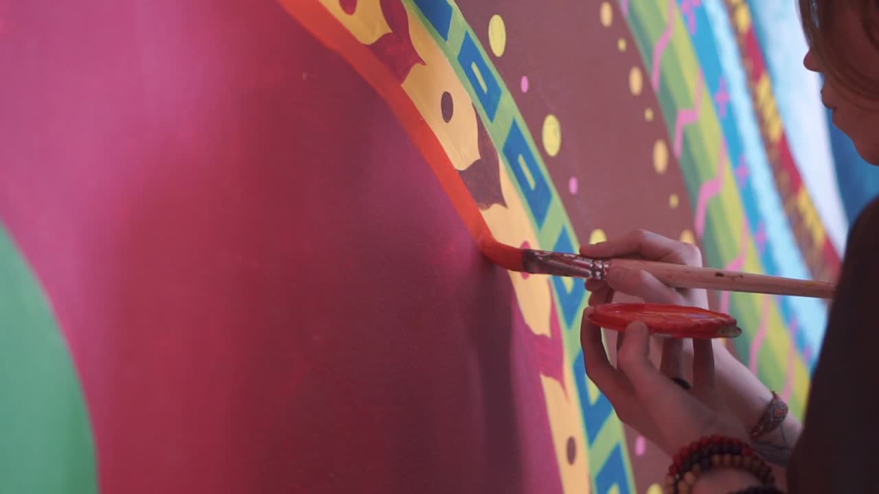 persona pintando un mural colorido