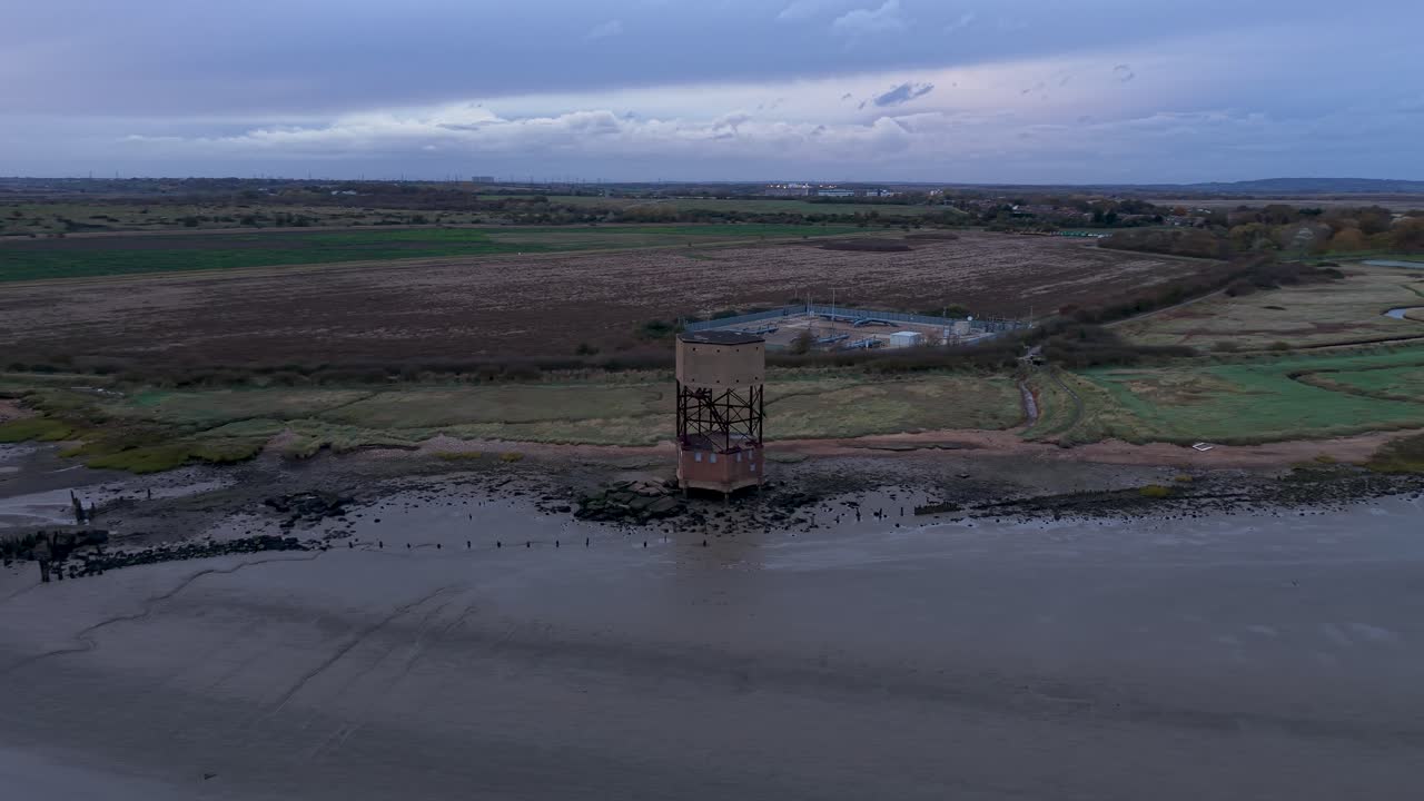 Aerial view circling the East Tilbury abandoned radar tower on the River Thames marshland foreshore