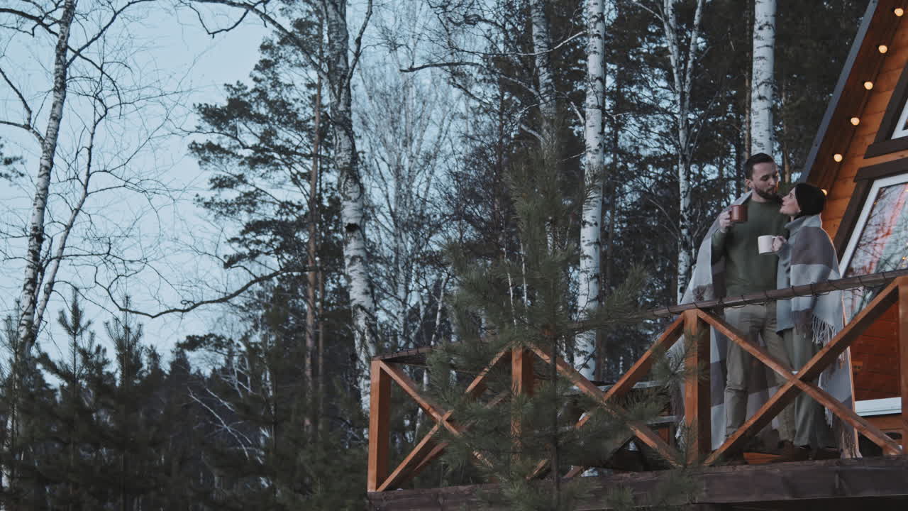 Couple Enjoying Hot Tea on Porch of Cabin