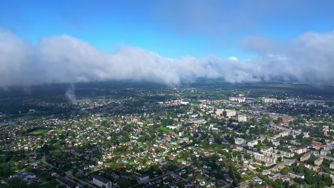 Shot of clouds moving over congested city at countryside during daytime from viewpoint.
