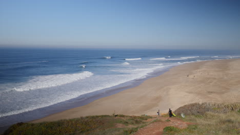 Surfista-Bajando-Por-El-Acantilado-En-Praia-Do-Norte,-Nazare