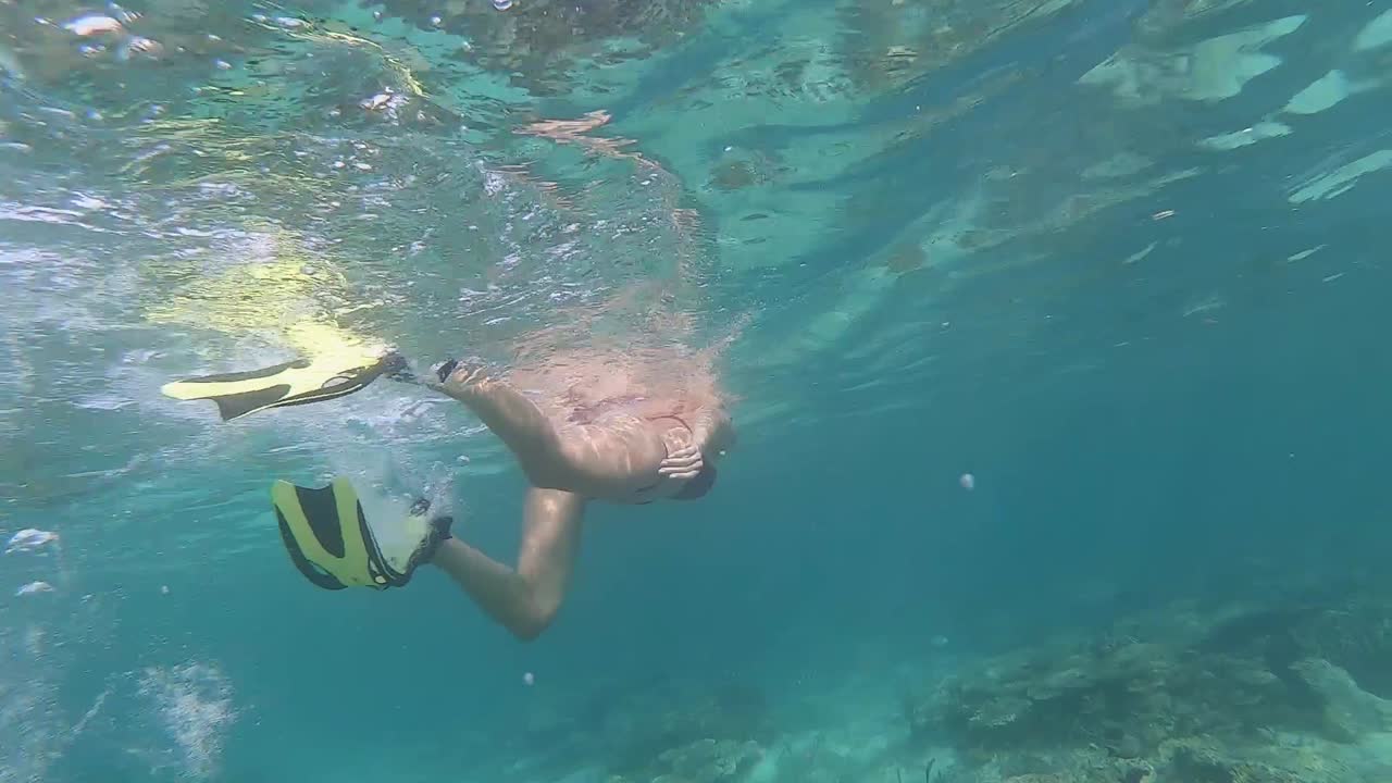 슬로우 모션으로 지느러미로 스노클링하는 소녀