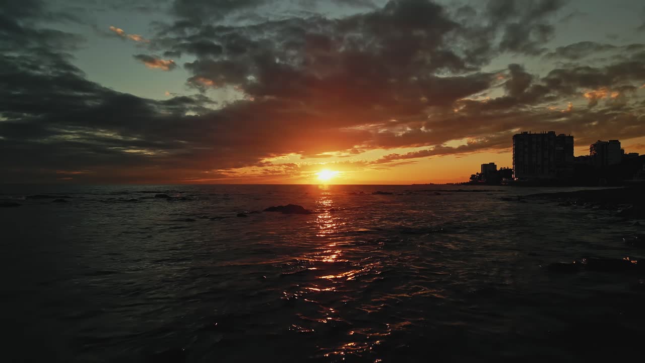 Dunkle Luftaufnahme von Sonnenuntergang oder Sonnenaufgang mit Dolly-In über dem Meer