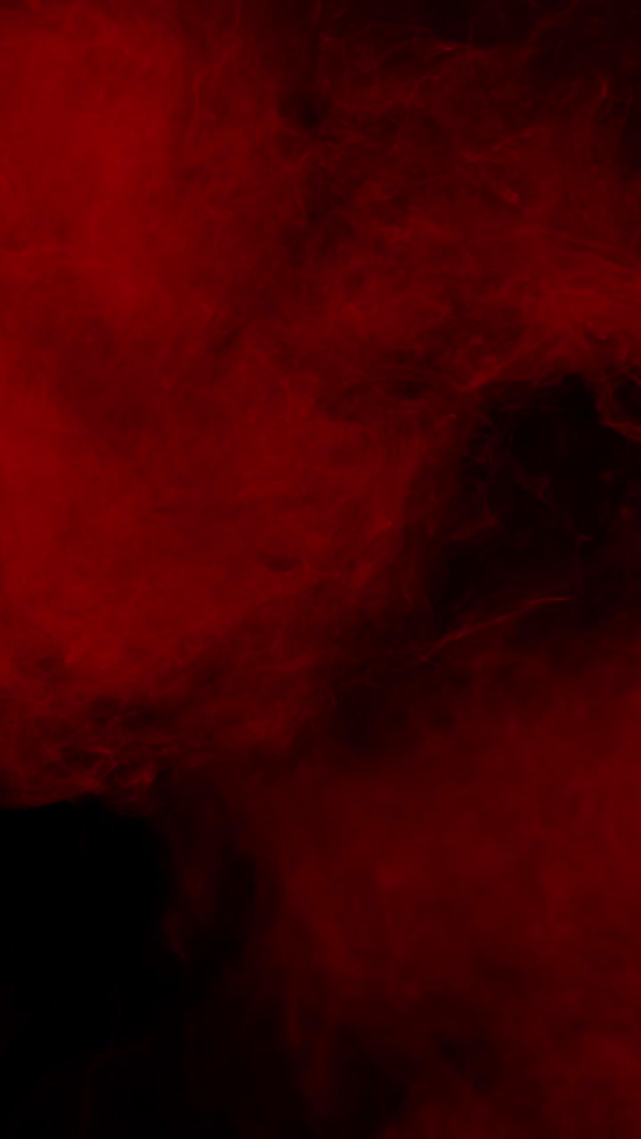 Formato verticale, fumo o nebbia rosso vivo che si espande su sfondo nero per un'atmosfera intensa, loop continuo