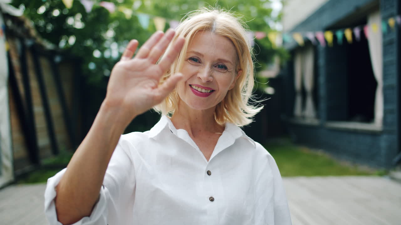 una mujer saludando.