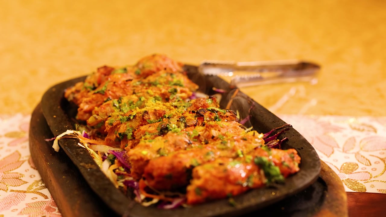 Tirisevä seekh kebab tarjoiltuna kuumalla rautalevyllä