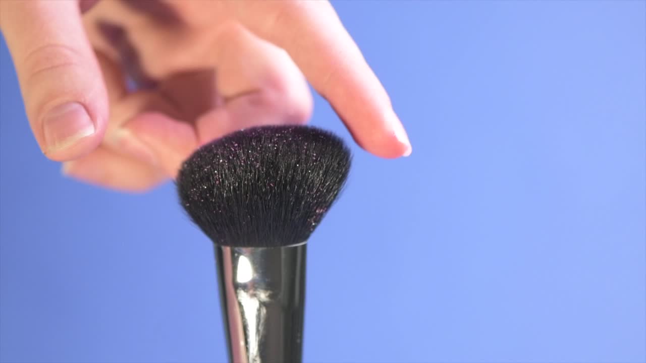 Close-up time lapse shot of a wide, fluffy cosmetic brush.