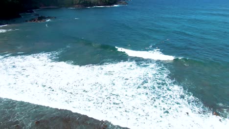 Aerial-orbiting-shot-of-Surfer-ride-a-wave-in-the-Koki-Beach-in-Maui-Coastline