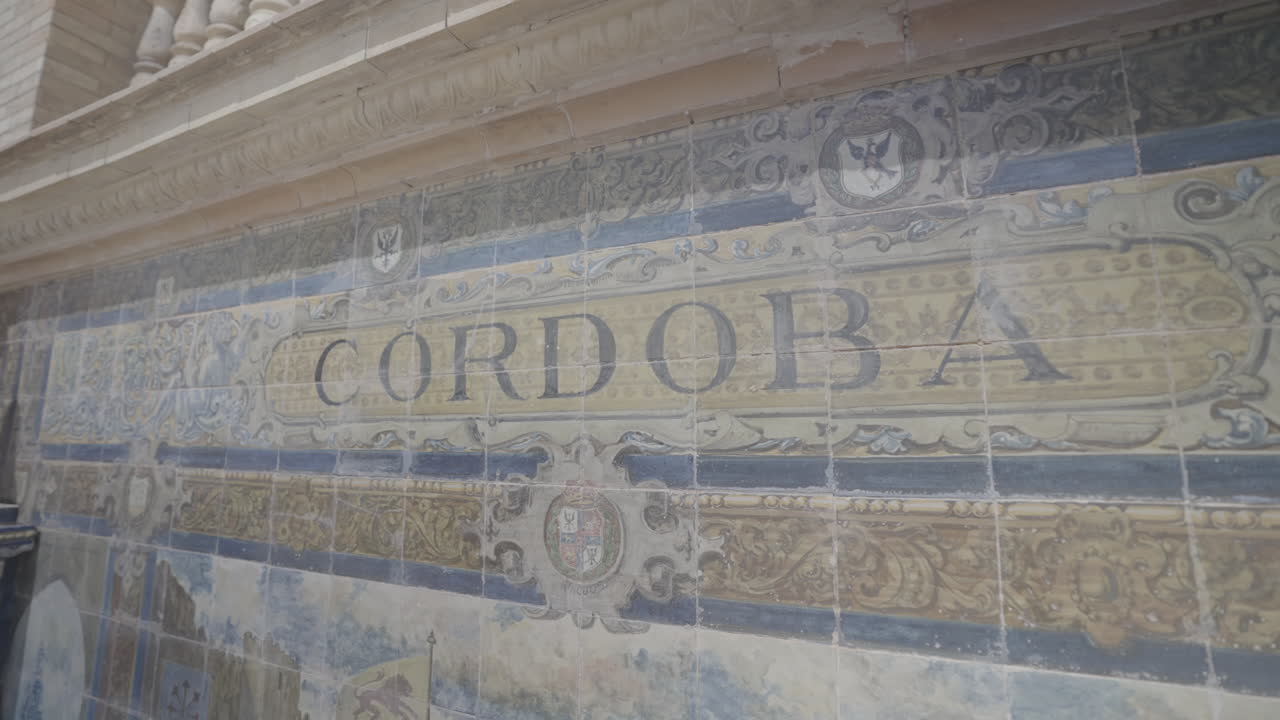 Close up shot of engraved tiles which show a drawing of Cordoba in slowmotion on Plaza de Espana in Sevilla Spain LOG