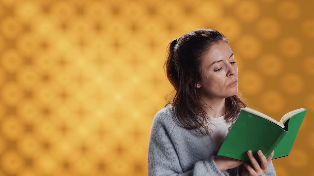mujer leyendo un libro, volviendo la página y sosteniendo un café, fondo del estudio