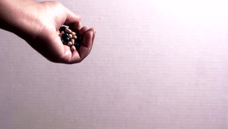 african american female hand tightly holding pharmaceuticals in hand and letting them fall from her hand