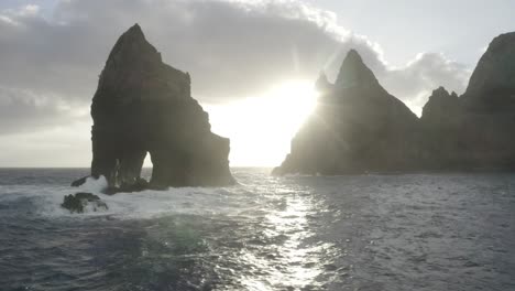 Drone-shot-of-a-desaturated-and-lifeless-bay-with-sharp-and-dramatic-cliffs-coming-up-from-the-ocean-in-Madeira